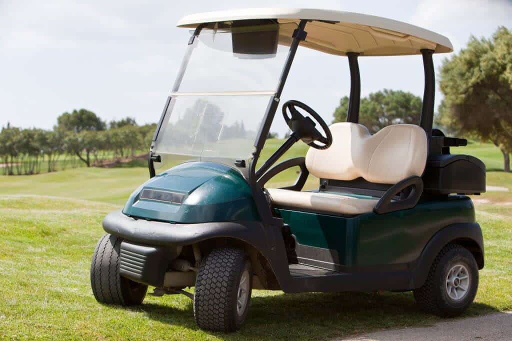 Empty electric golf cart parked on a fairway at a golf club in the hot summer sunshine