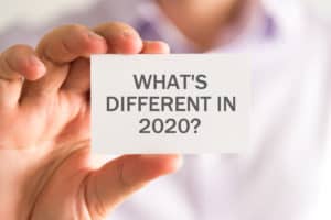 man holding business card that says whats different in 2020