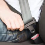 man sitting in chair fastening his seat belt