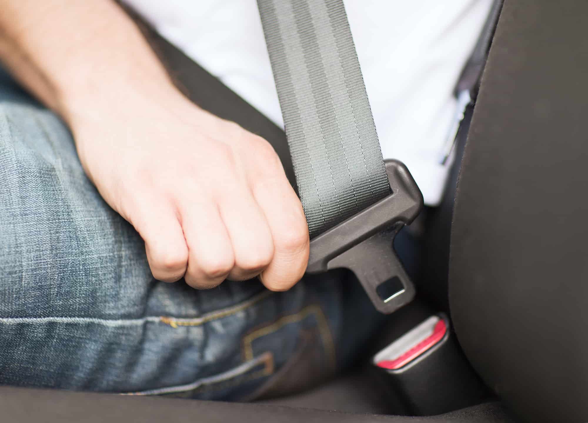 man sitting in chair fastening his seat belt