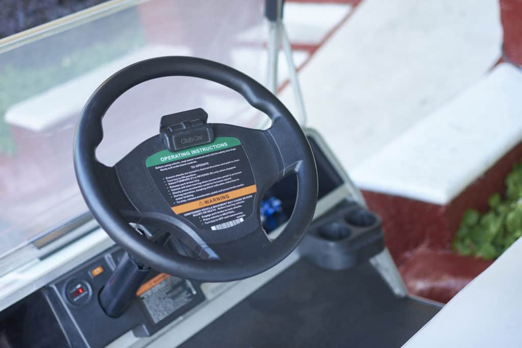 Steering wheel and dashboard of a club car, used for moving objects inside a resort in Mexico