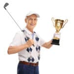 Joyful senior golfer holding a gold trophy and looking at the camera isolated on white background