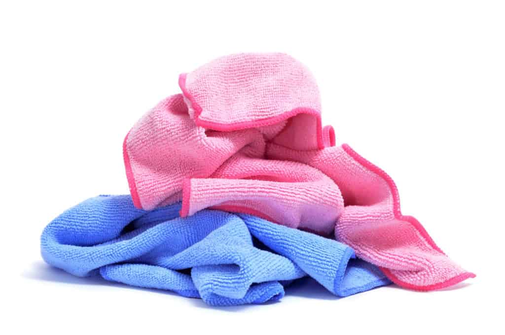 some microfiber dishcloths of different colors on a white background