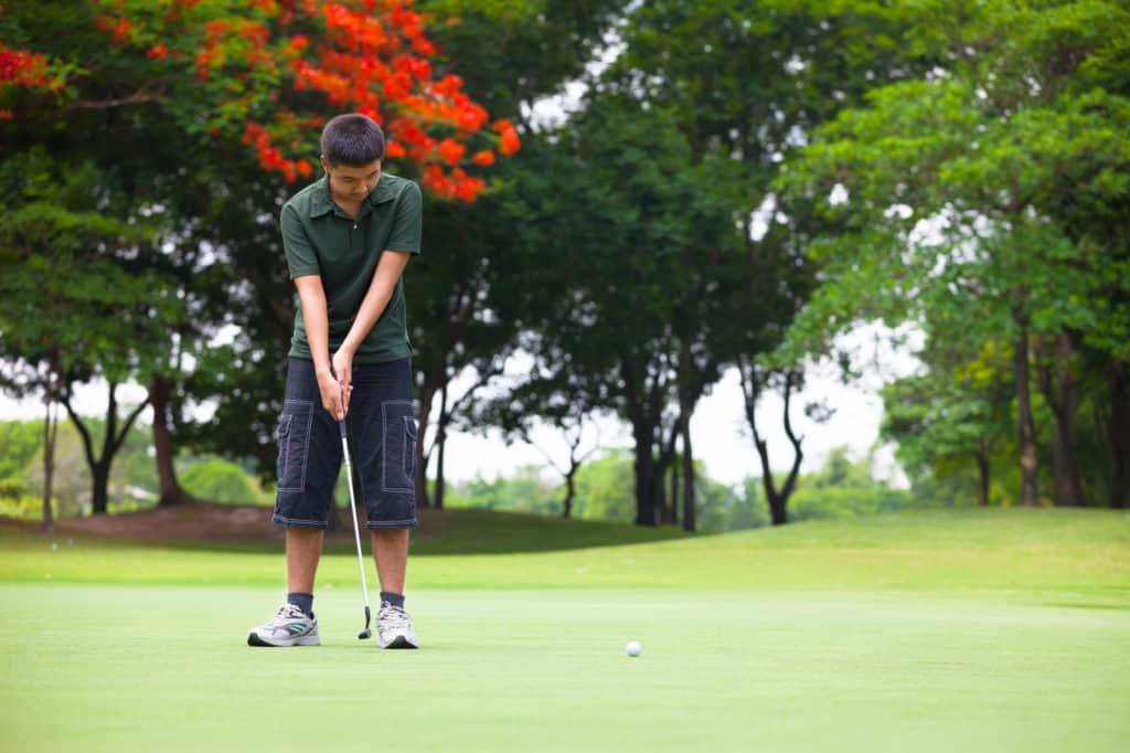 Young man looks on after the putt he has just made