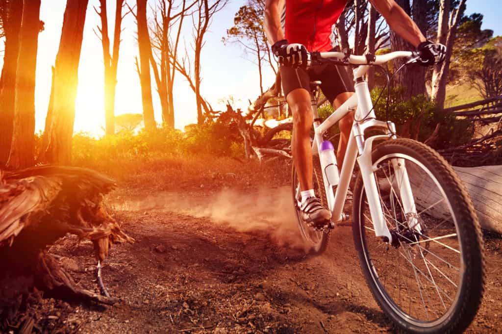 Mountain Bike cyclist riding single track at sunrise healthy lifestyle active athlete doing sport