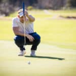 golfer lining up his shot on putting green