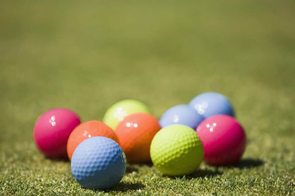 colored golf balls on grass