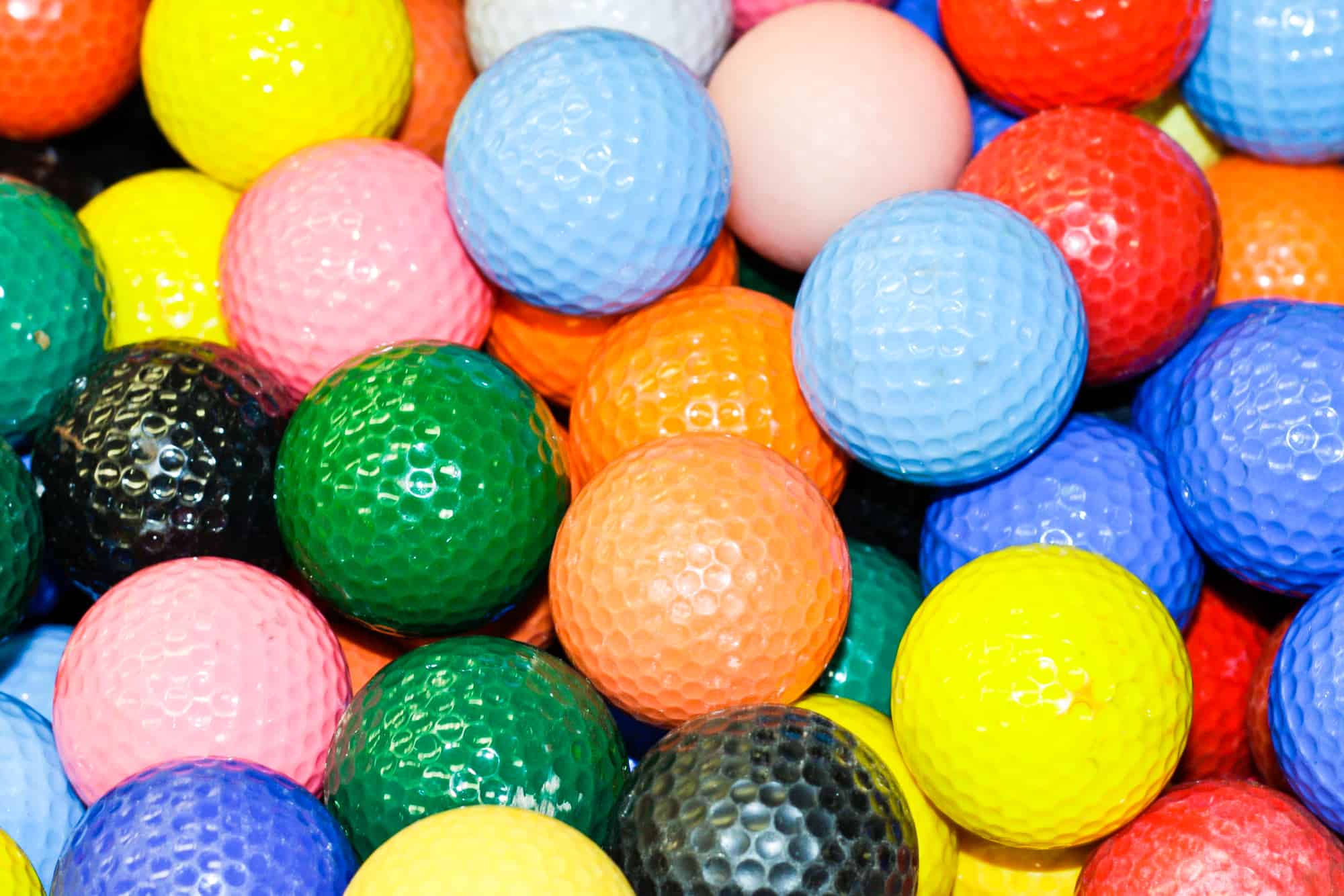 Close up of a pile of multi-colored golf balls