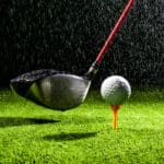 golf ball with golf club driver on the wet field