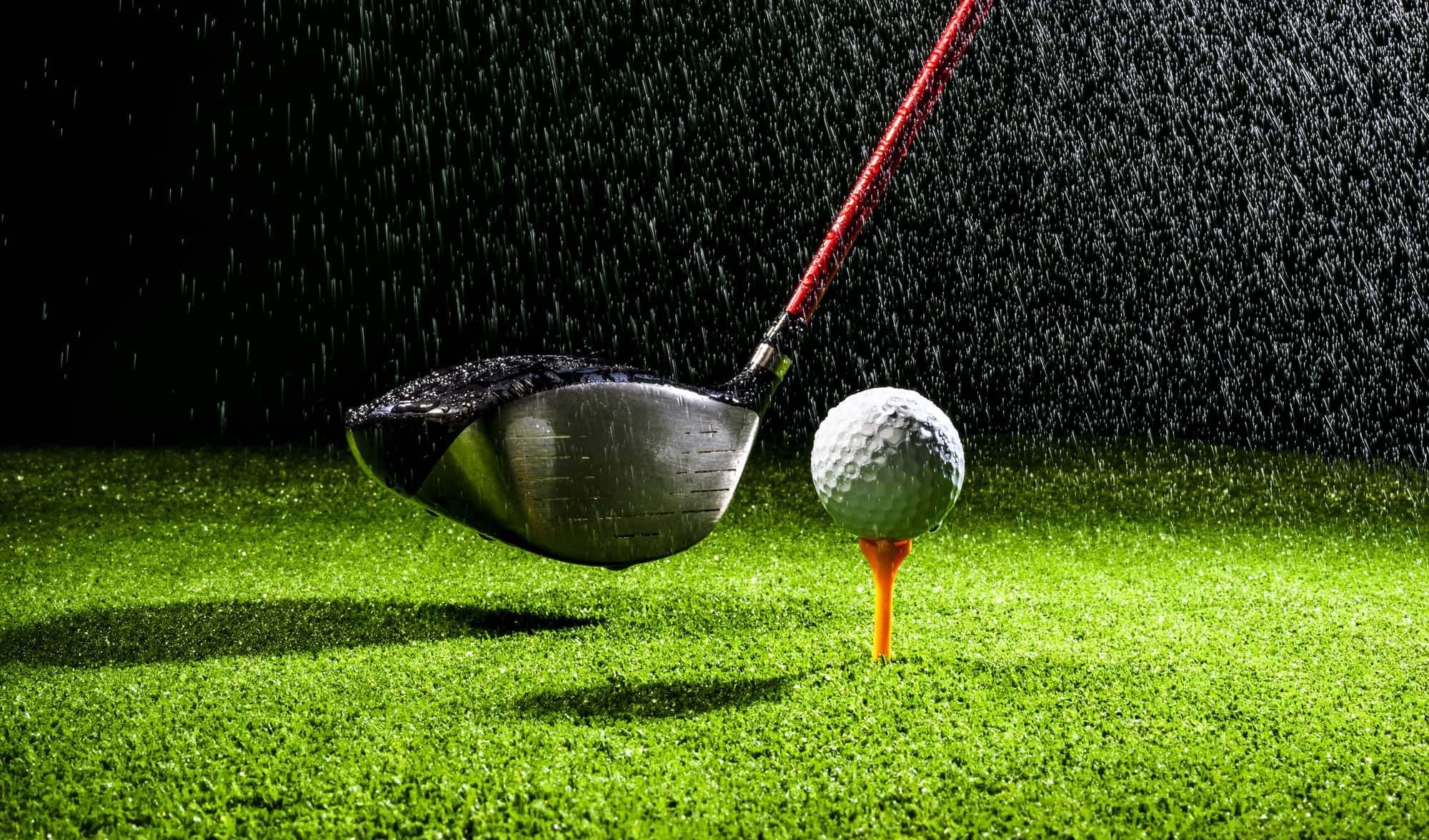 golf ball with golf club driver on the wet field