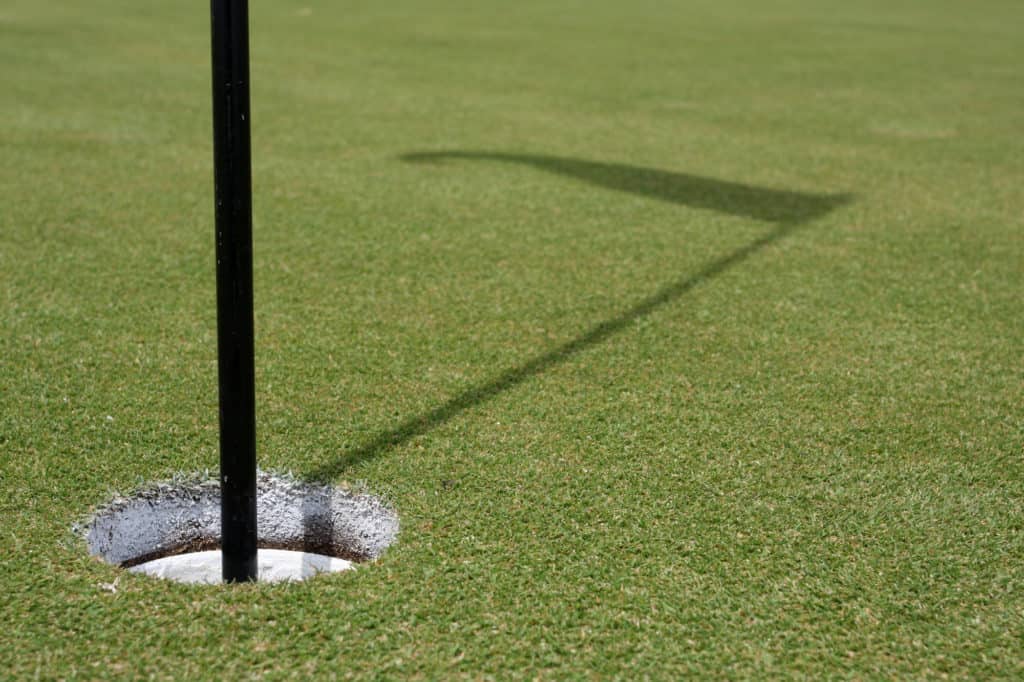 Hole of the green with the flag shadow