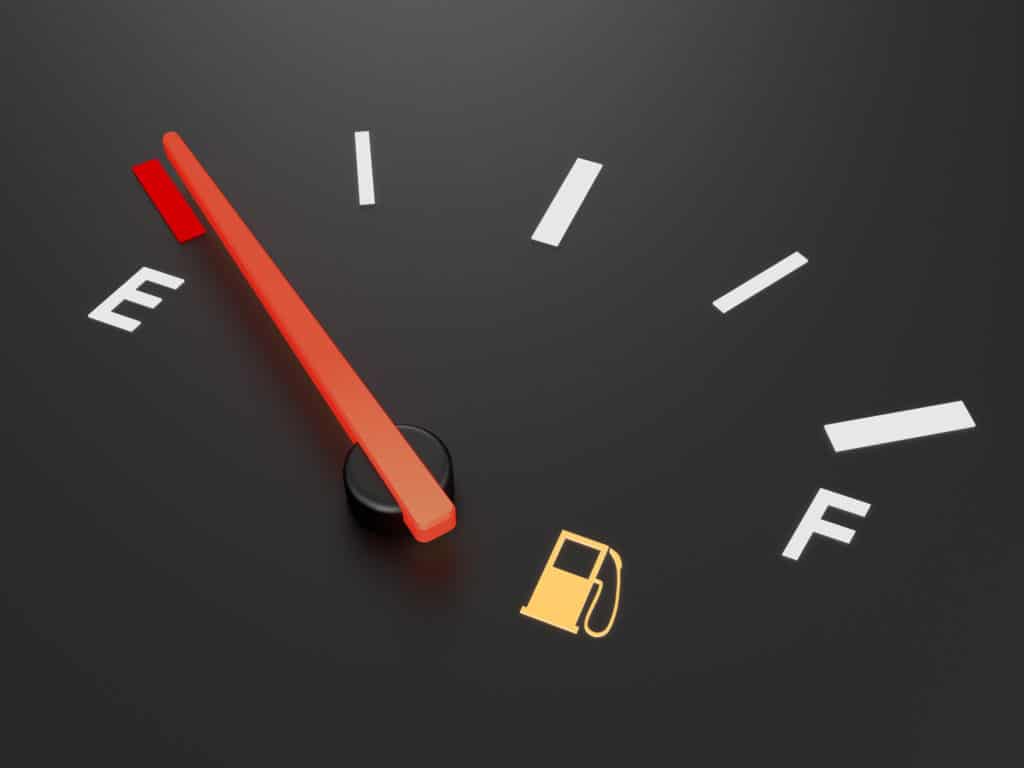 A closeup of a car fuel gauge showing empty