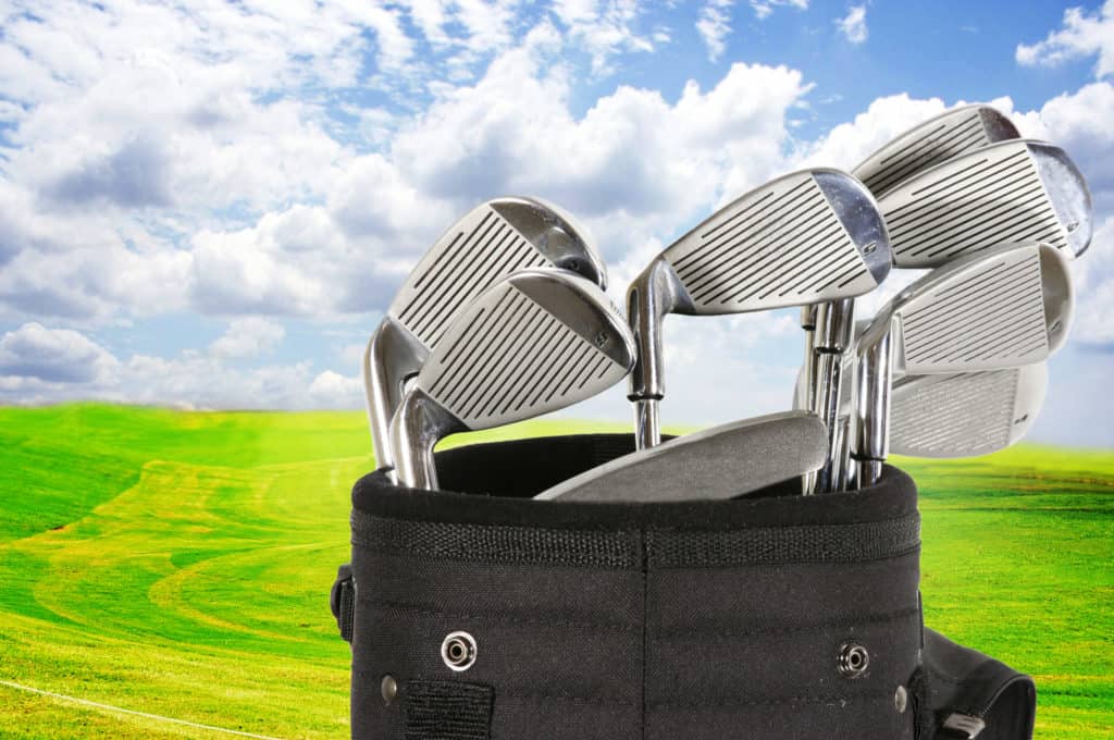 Golf bag with clubs against a beautiful fairway and a blue sky