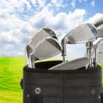 Golf bag with clubs against a beautiful fairway and a blue sky
