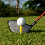 graphite golf driver ready to hit golf ball on tee