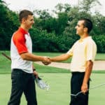 Friends shaking hands after golf game.