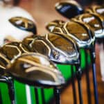 A shiny metal golf clubs for sale show in shop rack.