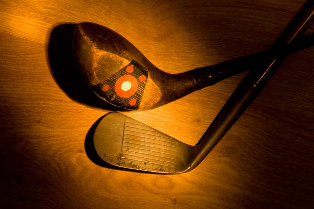 older golf clubs on wood background