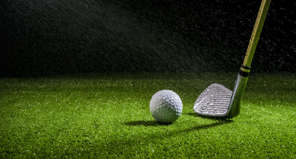 golf ball with golf club on the wet field