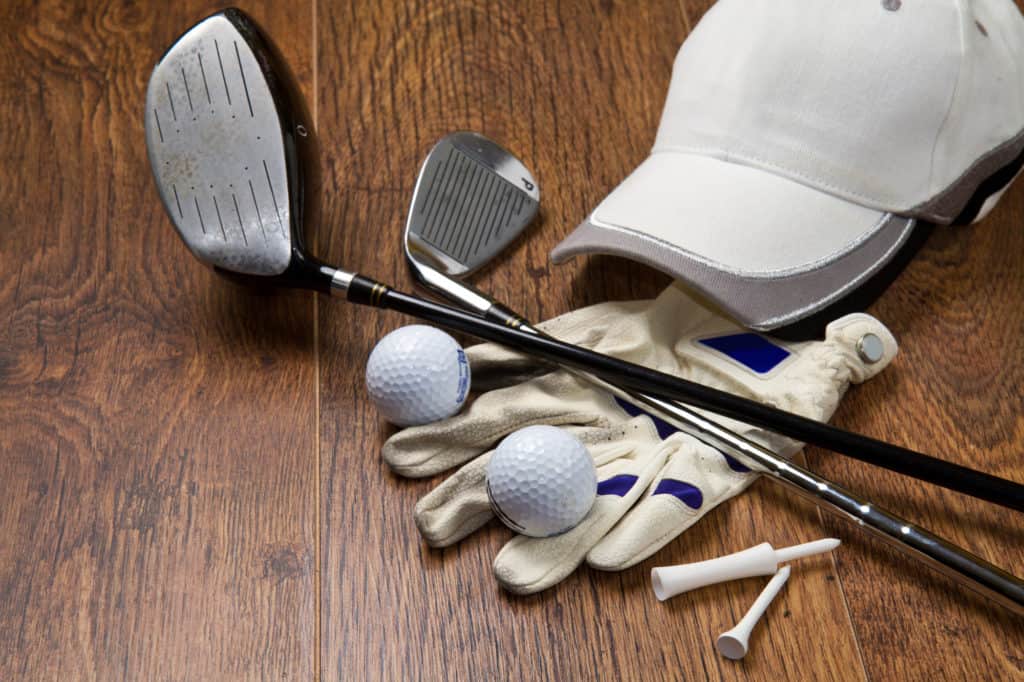 golf clubs with tees and hat