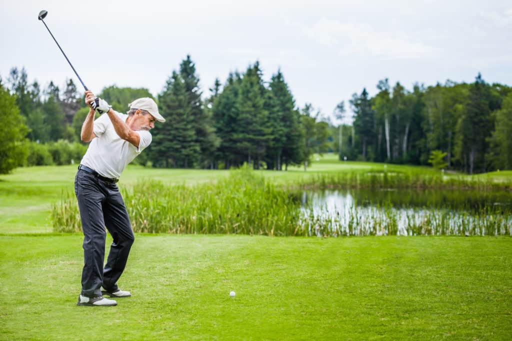 Mature Golfer on a Golf Course Taking a Swing on the Start