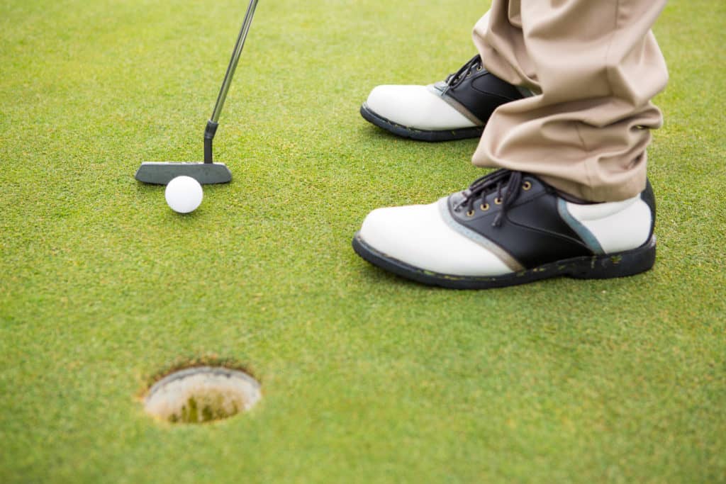 Golfer about to tee off on a sunny day at the golf course