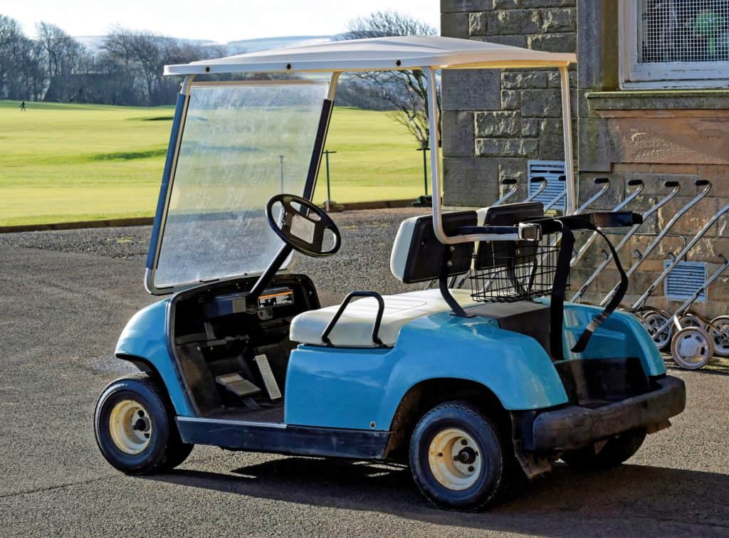 blue golf cart parked on curb