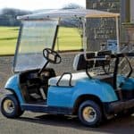 blue golf cart parked on curb