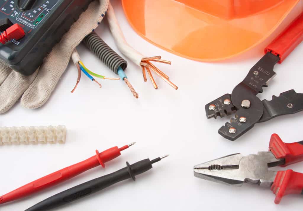 Electrician's tools. Hardhat, multimeter, pliers, cutter, cables, etc.