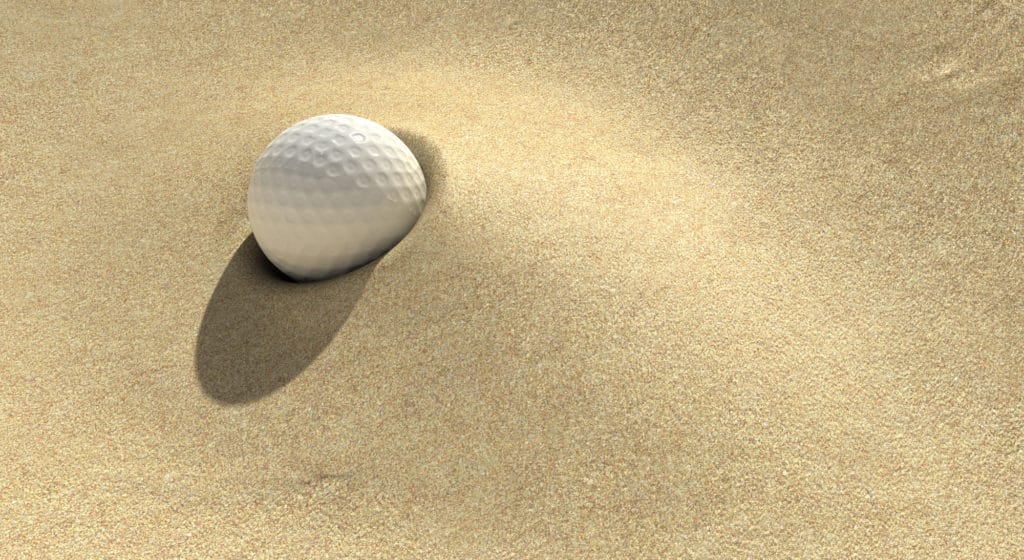 A golf ball plugged deep in a sand trap