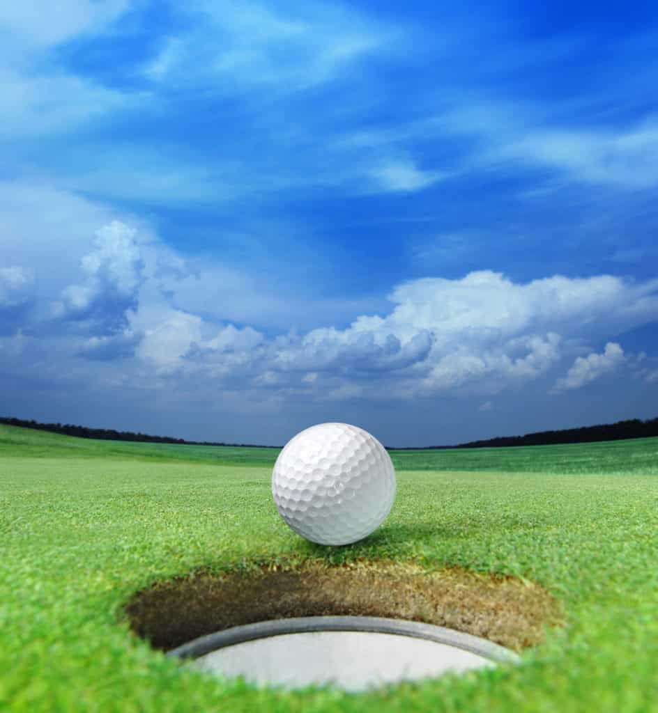golf ball on lip of cup of lovely beautiful golf course
