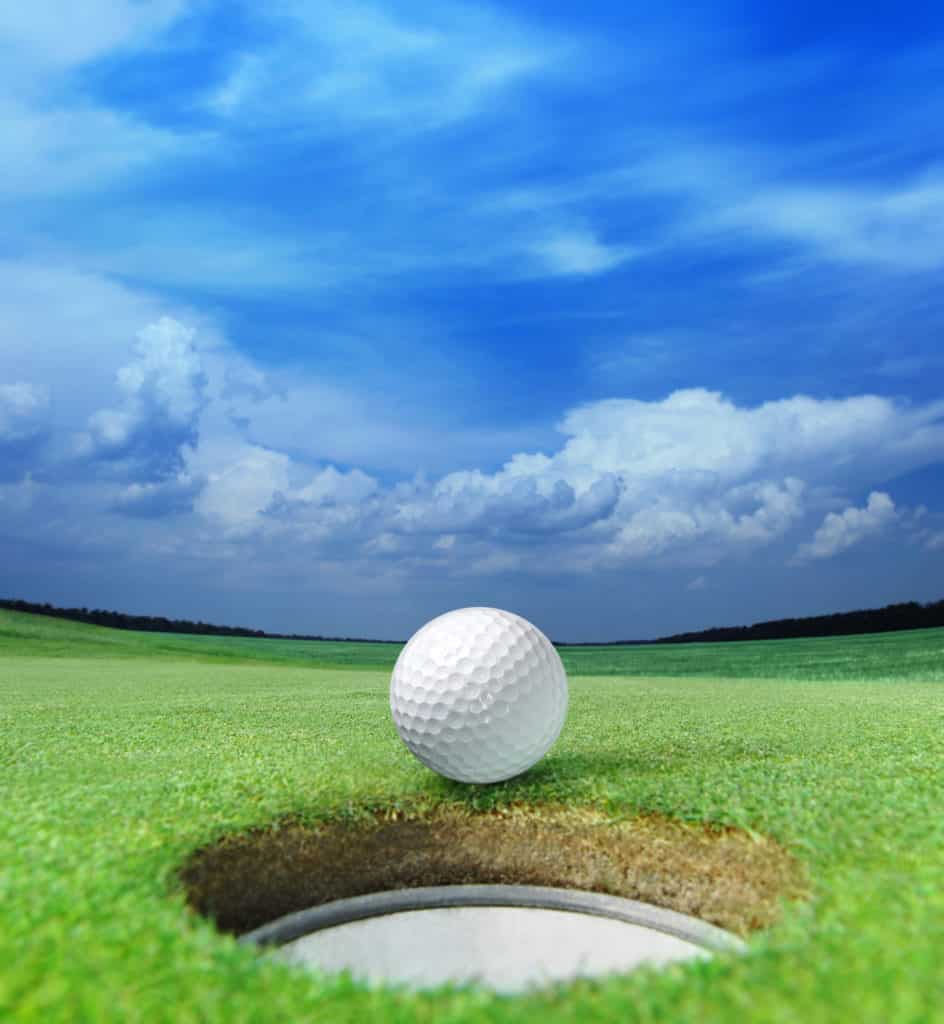 golf ball on lip of cup of lovely beautiful golf course