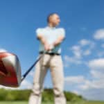 Low angle view of man holding golf club against sky