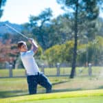 image of a golfer playing a chip shot onto the green on a golf course in south africa