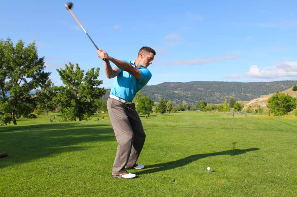 Young male golfer hitting a driver from the tee-box