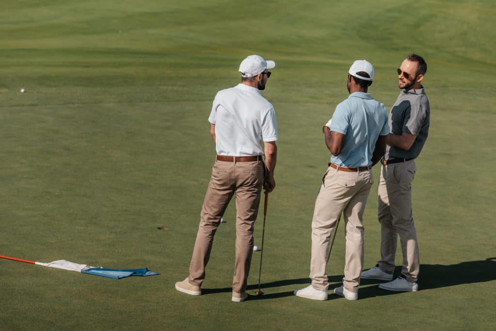 golfers talking on green pitch