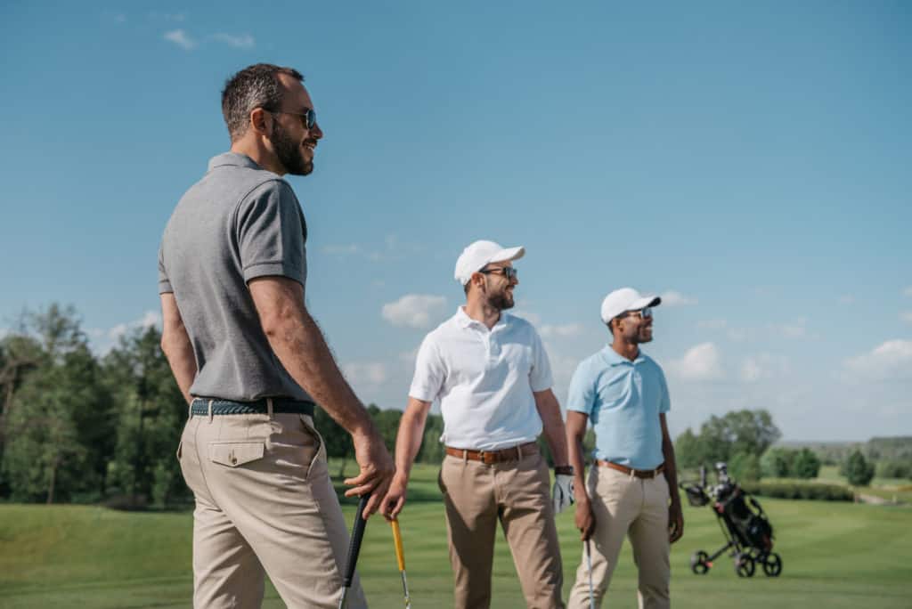 Men golfing looking at shot