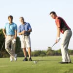 Group Of Male Golfers Teeing Off On Golf Course