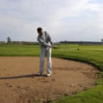 Golf player make a sand shot