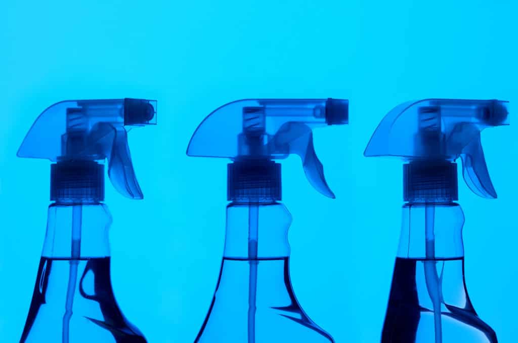 Three spray bottles on blue back ground looking like an x-ray