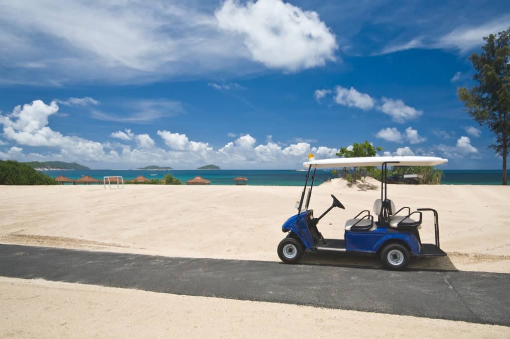 Golf cart on a beach with blue sky