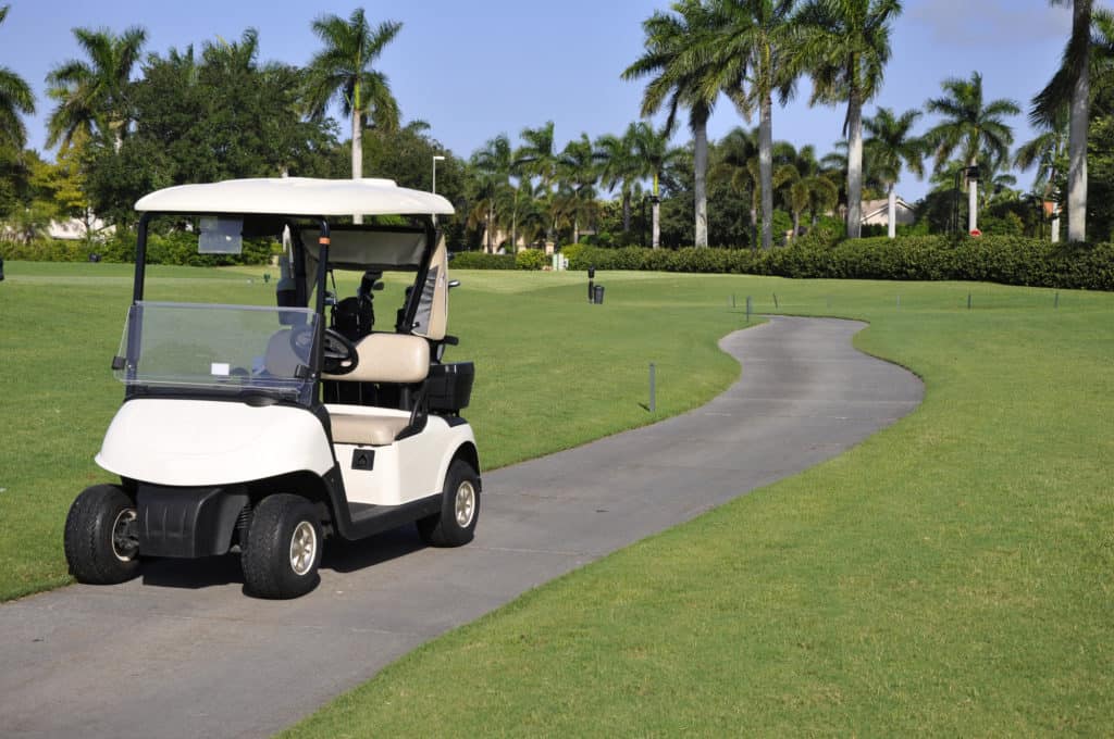 empty golf cart by golf course