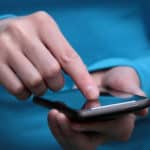 Hand holding smartphone and finger tapping on the screen