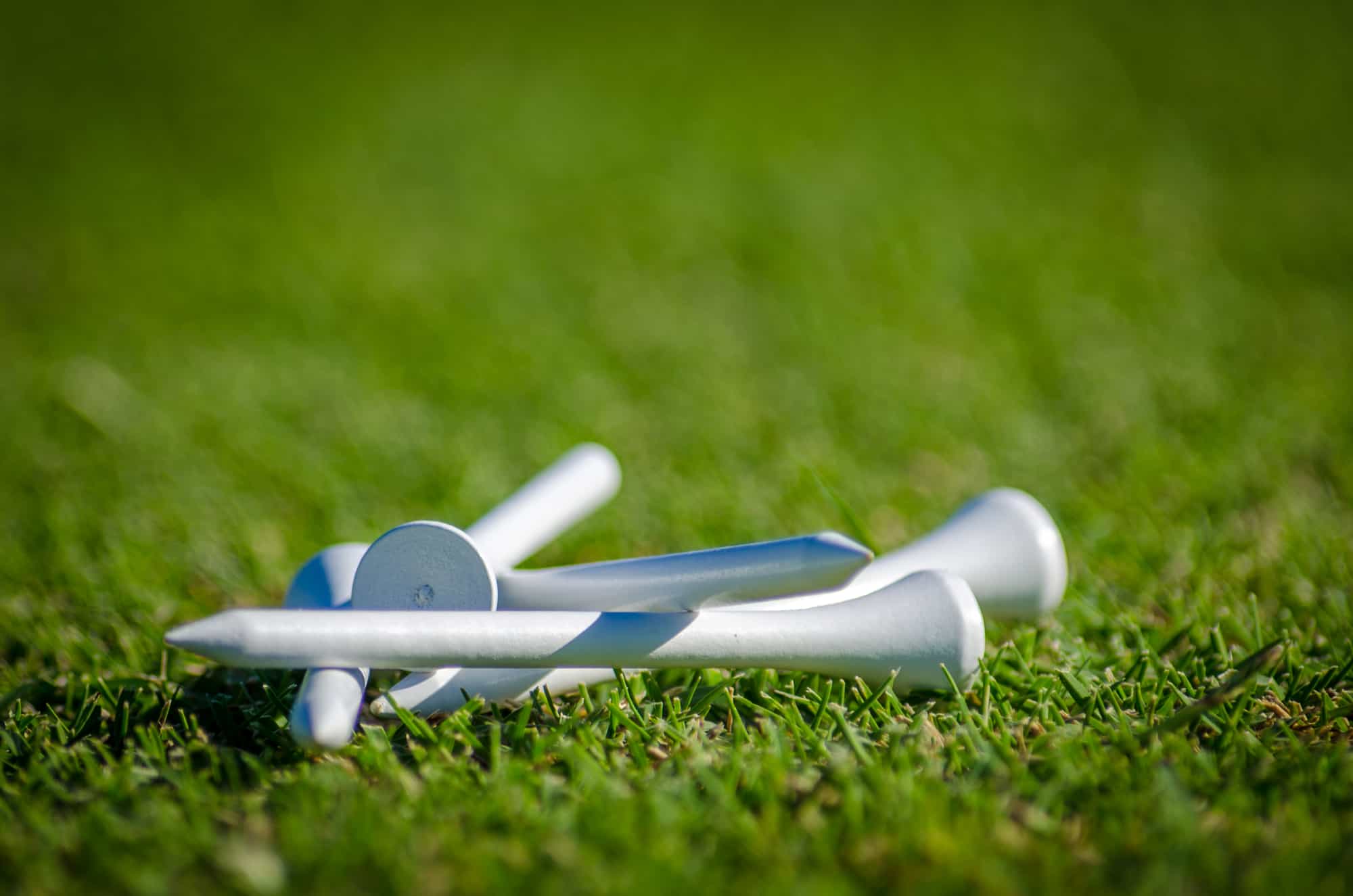 White golf tees on the grass