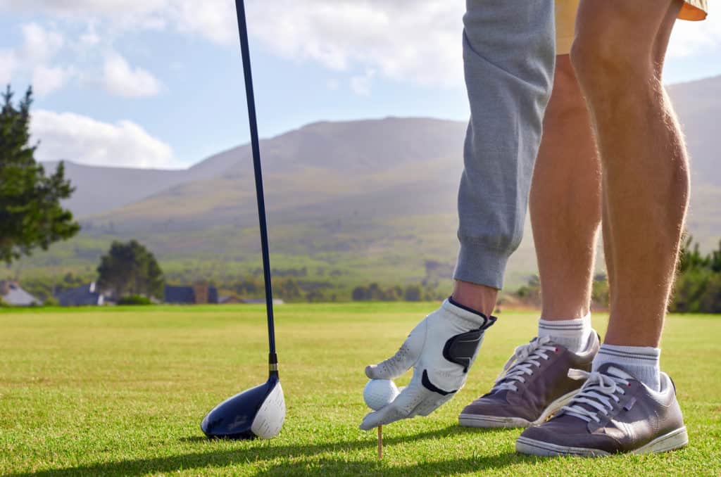 golf man placing ball pin for tee shot on vacation