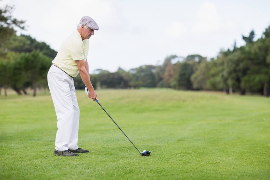 Side view of mature man playing golf