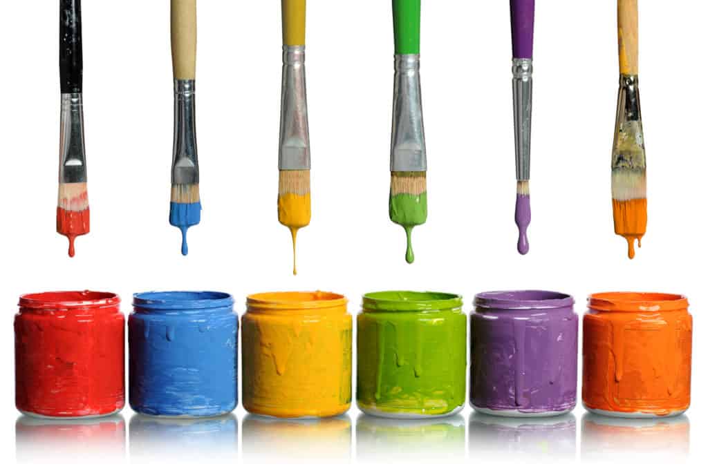 Paint brushes Dripping into Paint Containers