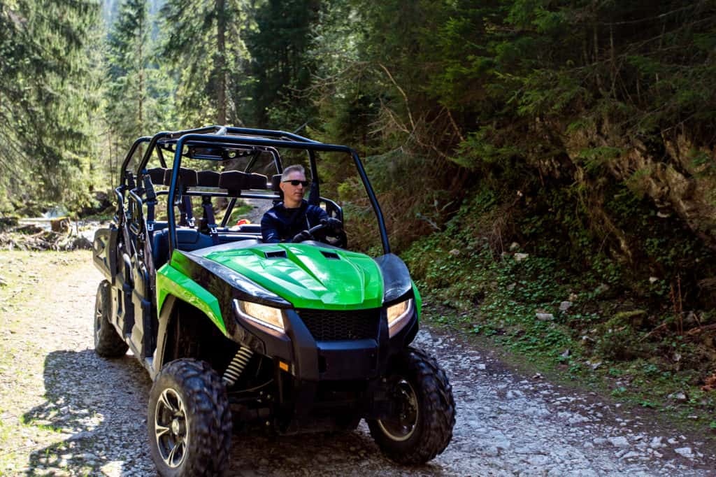 A tour group travels on ATVs and UTVs on the mountains