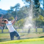 image of a golfer playing a chip shot onto the green on a golf course in south africa