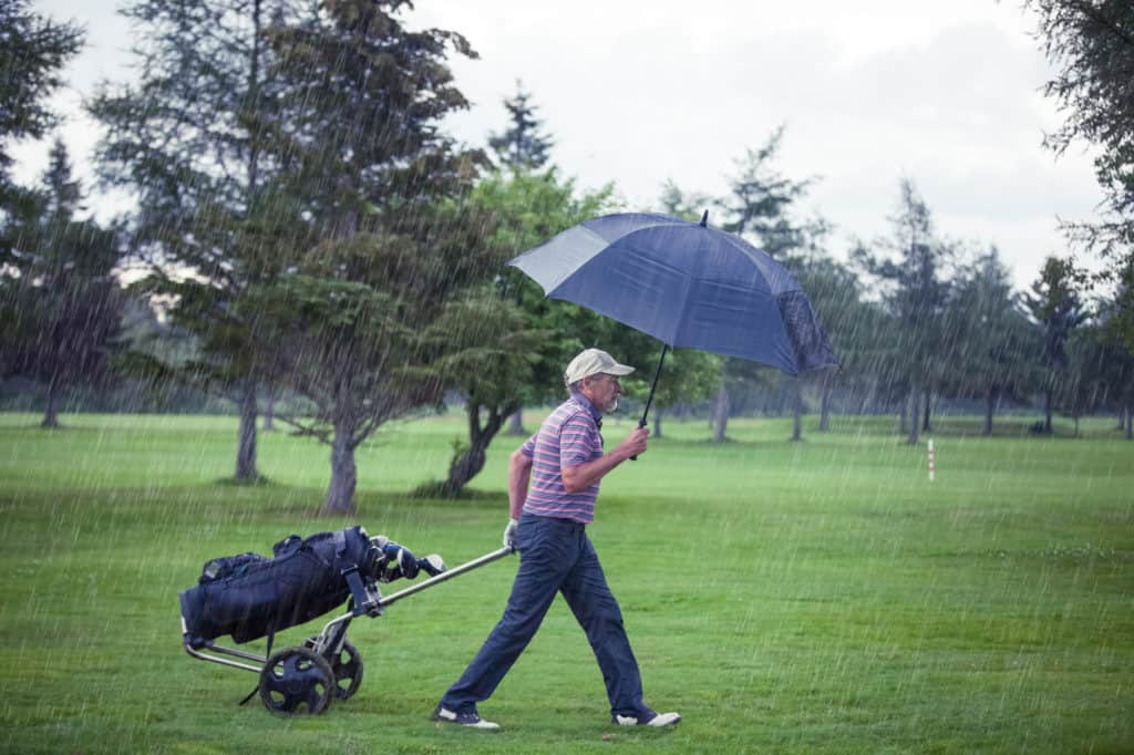 Golfer on a Rainy Day Leaving the Golf Course